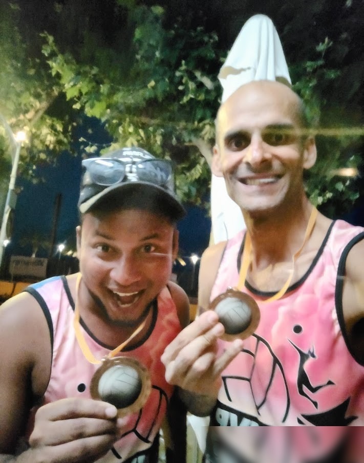Jimmy Humania and teammate showing beach volleyball medals in Spain