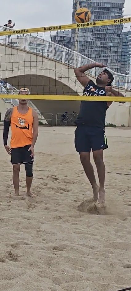 Jimmy Humania mid-air spiking beach volleyball in Spain