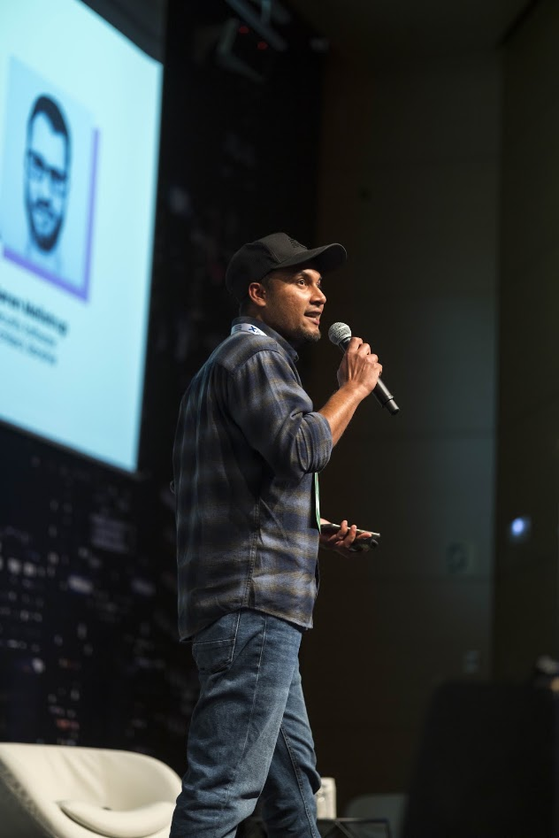 Jimmy Humania speaking on stage with microphone